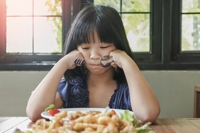 Pediatric Feeding Problem Young asian child looking at food and won't eat
