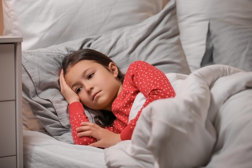 Child lying awake in bed unable to sleep